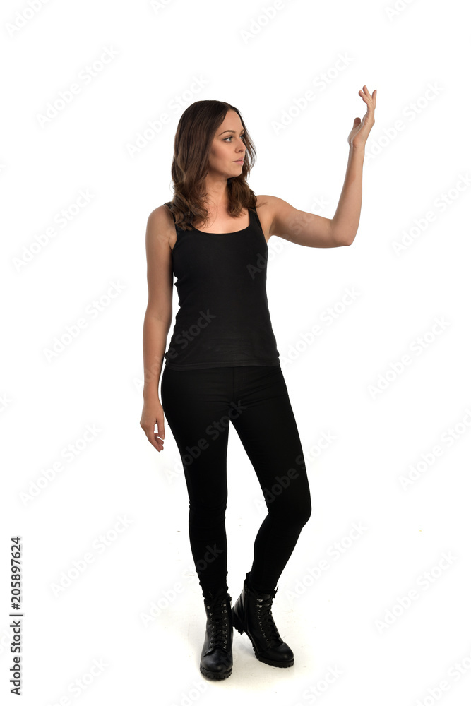 full length portrait of brunette girl wearing black singlet, jeans jeans and boots. standing pose, isolated on white studio background. full length portrait of brunette girl wearing black singlet, jeans jeans and boots. standing pose, isolated on white studio background.