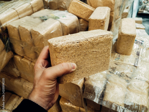 Alternative fuel, eco fuel, bio fuel. Wood sawdust briquettes for stoves. Lean-burn with good heat output. Briquettes from sawdust on a green background.