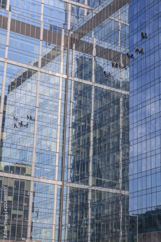 Industrial climbers wash the facade of modern high-rise building