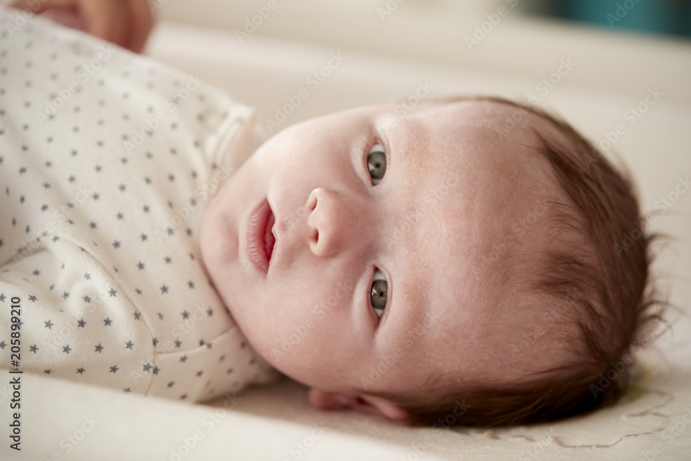 Close Up Of Newborn Baby Boy Lying On Changing Table In Nursery Close Up Of Newborn Baby Boy Lying On Changing Table In Nursery