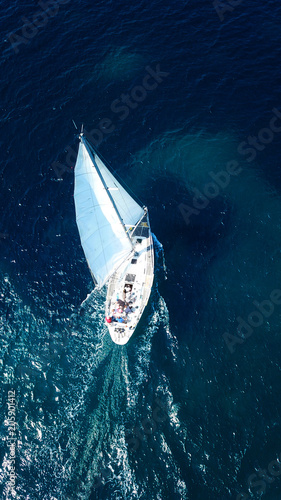 Aerial birds eye view from drone of yacht in deep blue sea