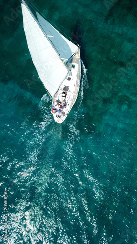 Aerial birds eye view from drone of yacht in deep blue sea