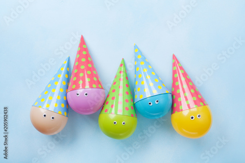 Colorful funny balloons on blue table top view. Festive or party background. Flat lay. Birthday greeting card.