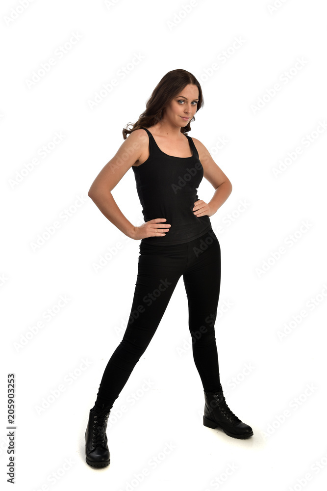 full length portrait of brunette girl wearing black singlet, jeans jeans and boots. standing pose, isolated on white studio background. full length portrait of brunette girl wearing black singlet, jeans jeans and boots. standing pose, isolated on white studio background.