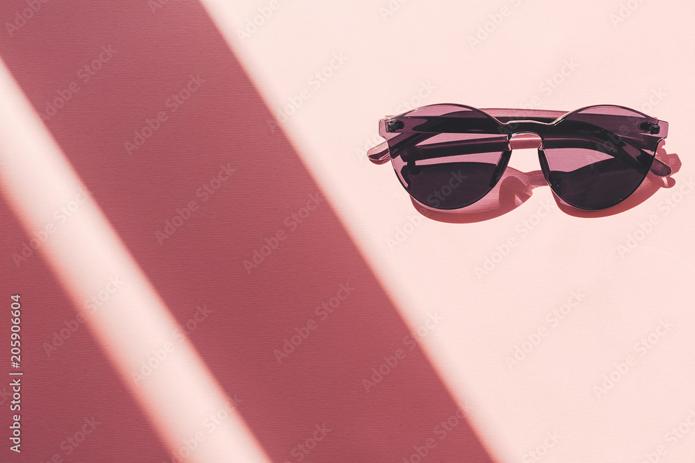 summer vacation and party concept. stylish black sunglasses on trendy pink paper background in sun light. flat lay. space for text. travel and wanderlust concept. summer vacation and party concept. stylish black sunglasses on trendy pink paper background in sun light. flat lay. space for text. travel and wanderlust concept.