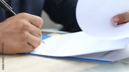 Asian Business man Manager checking and signing applicant filling documents reports papers company application form or registering claim on desk office. Document Report and business busy Concept