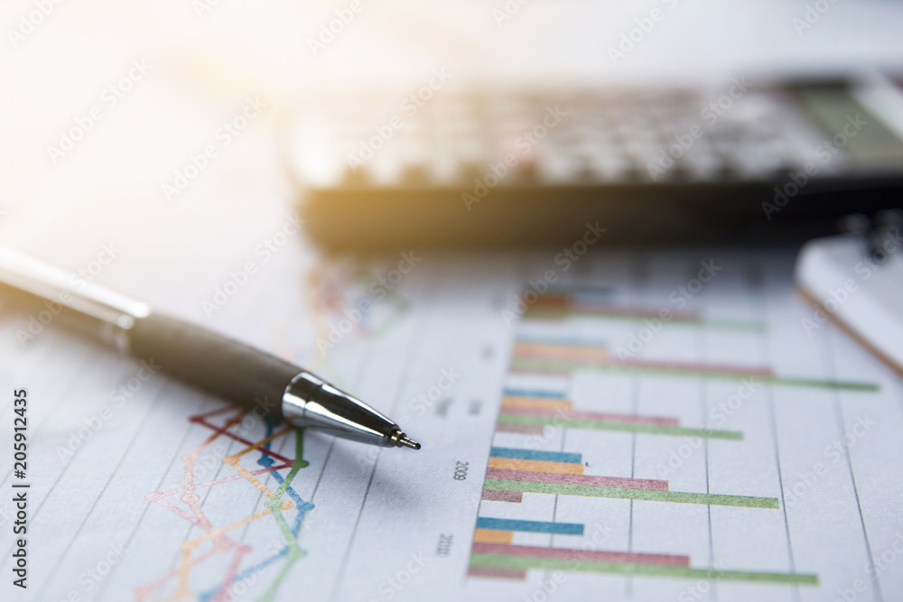 Financial analyzing concept, Pen and calculator on paperwork Financial analyzing concept, Pen and calculator on paperwork