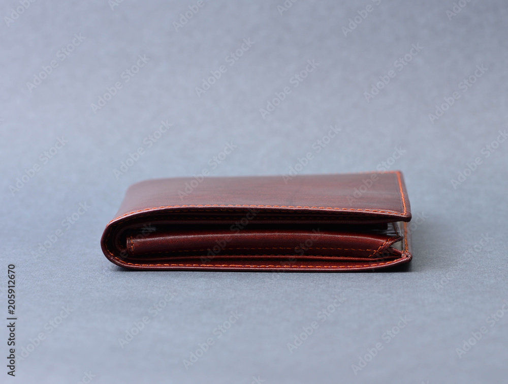 Brown leather wallet on gray texture Brown leather wallet on gray texture