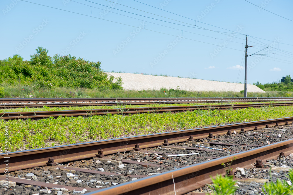 railtracks with power lines and blue sky