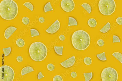 Lemon and lime slice and fresh citrus fruit on yellow background.