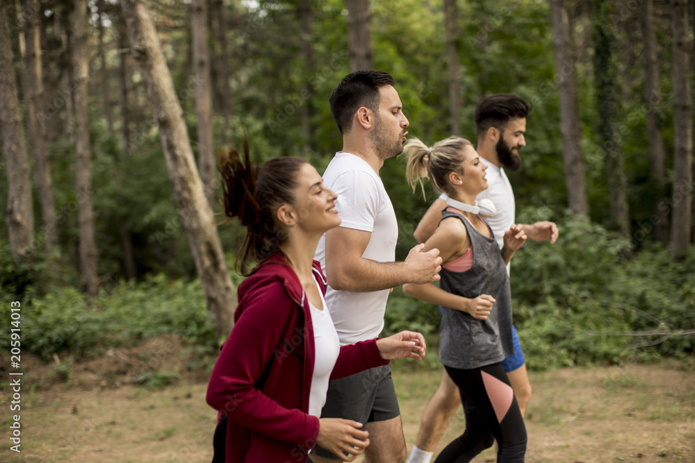 Fototapeta premium Young people run a marathon through the forest