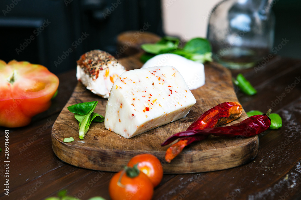 Piece of cheese with pepper on a wooden board. Italian style rustic cheese