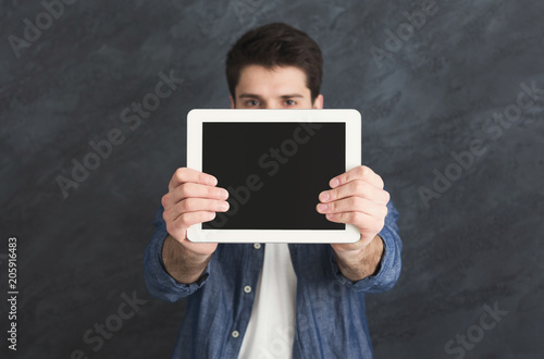 Handsome man holding digital tablet in studio