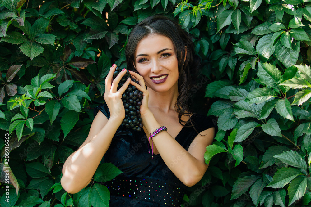 Portrait of young sexy brunette with black grapes. Portrait of young sexy brunette with black grapes.