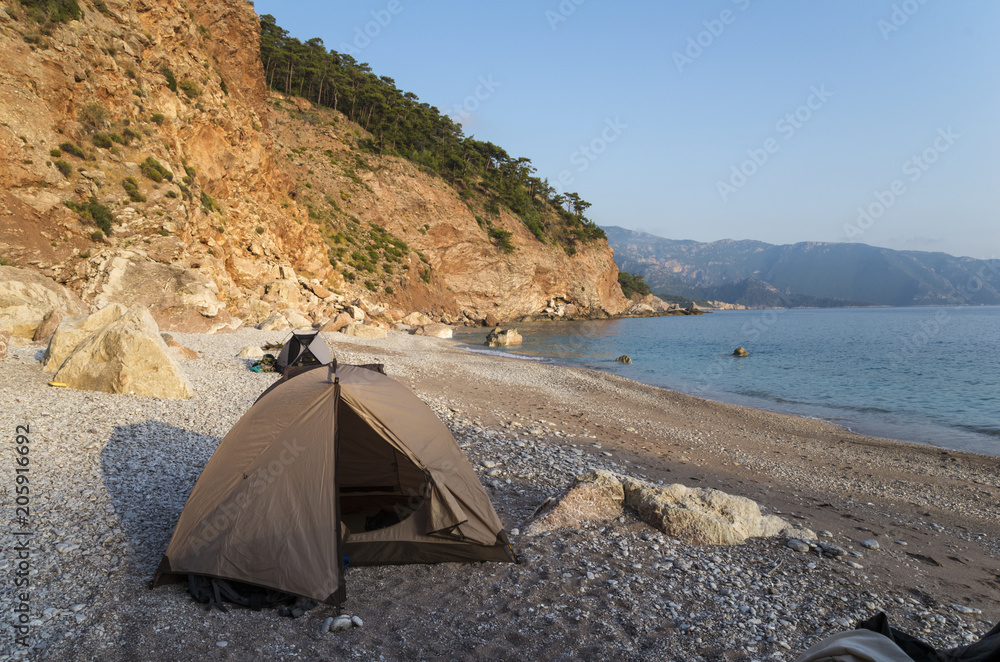 Camping by the sea at sunset. Beach with tents.