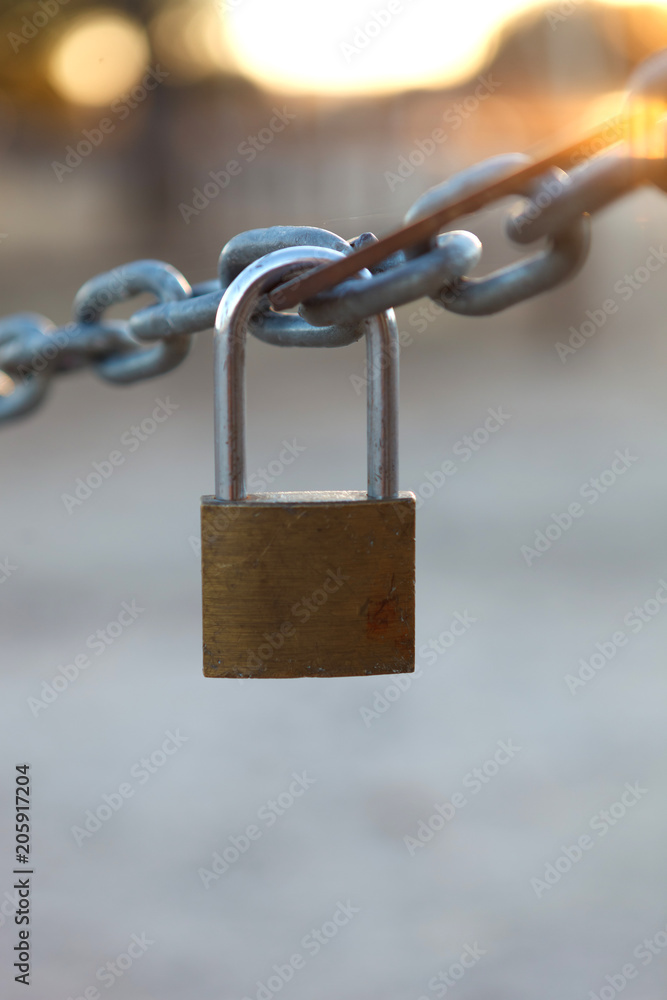 Closed padlock hanging from a chain Closed padlock hanging from a chain