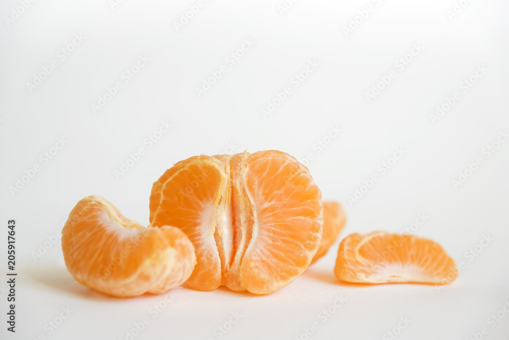 Isolated citrus segments. Collection of tangerine, orange and other citrus fruits peeled segments isolated on white background with clipping path Isolated citrus segments. Collection of tangerine, orange and other citrus fruits peeled segments isolated on white background with clipping path