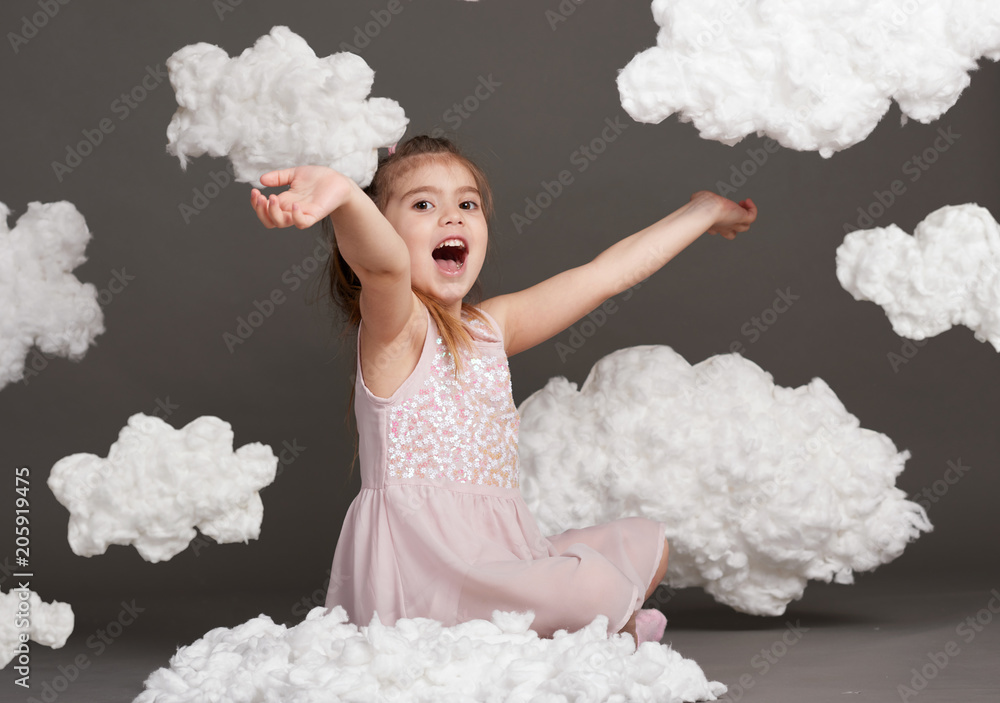 girl playing with clouds, shot in the studio on a gray background girl playing with clouds, shot in the studio on a gray background