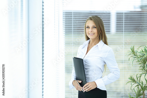 young business woman with clipboard in the background of the office.