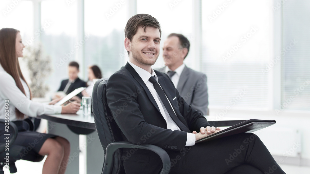 business man at office with his business team working behind business man at office with his business team working behind