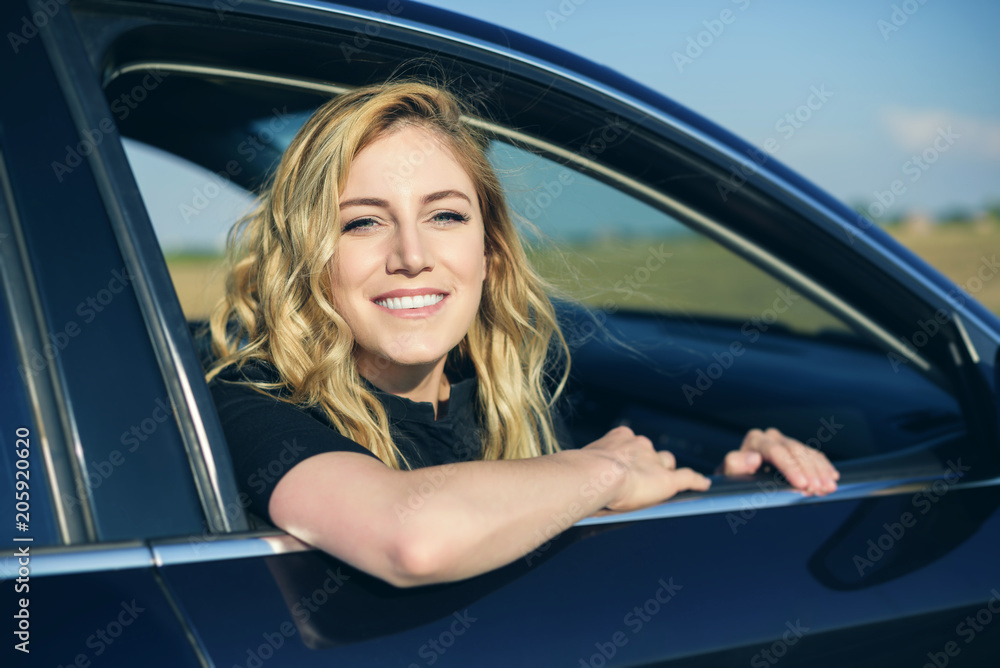 Smiling woman in the car on a summer day. Smiling woman in the car on a summer day.