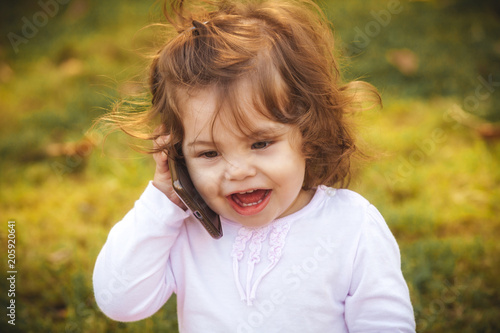 little girl with a mobile phone in the park