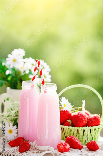 Strawberry cocktail or milkshake in a jar, basket with strawberries on a picnic, healthy food for Breakfast and snacks. Selective focus.