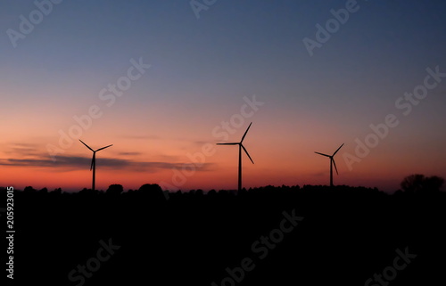 Drei Windkraftwerke am Abend