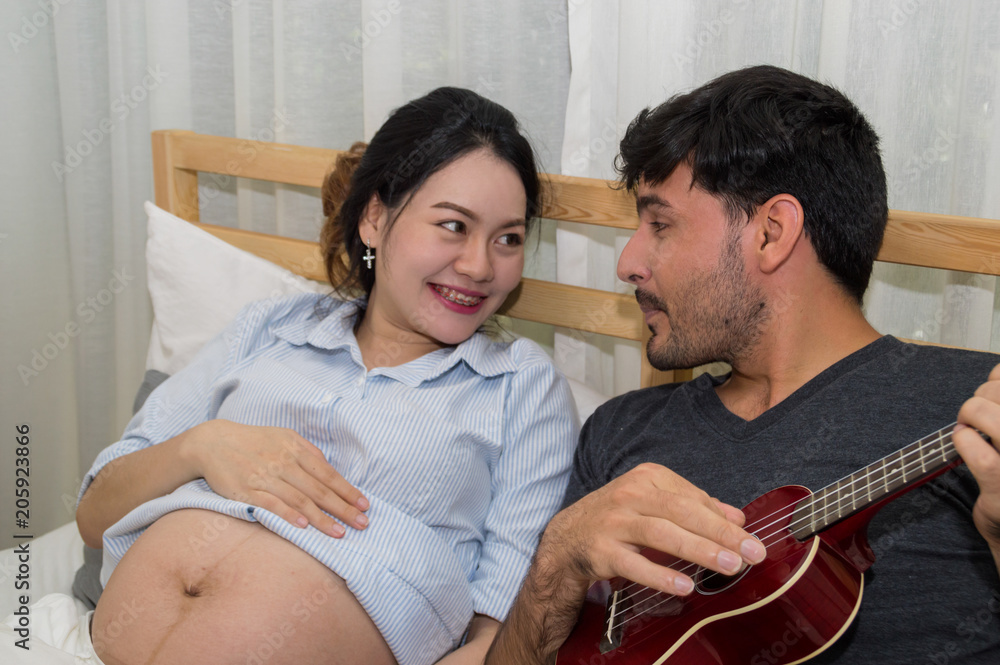 Men playing music for pregnant women in the bedroom.