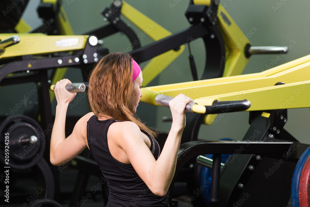 Beautiful woman at the gym exercising on a machine. Beautiful woman at the gym exercising on a machine.