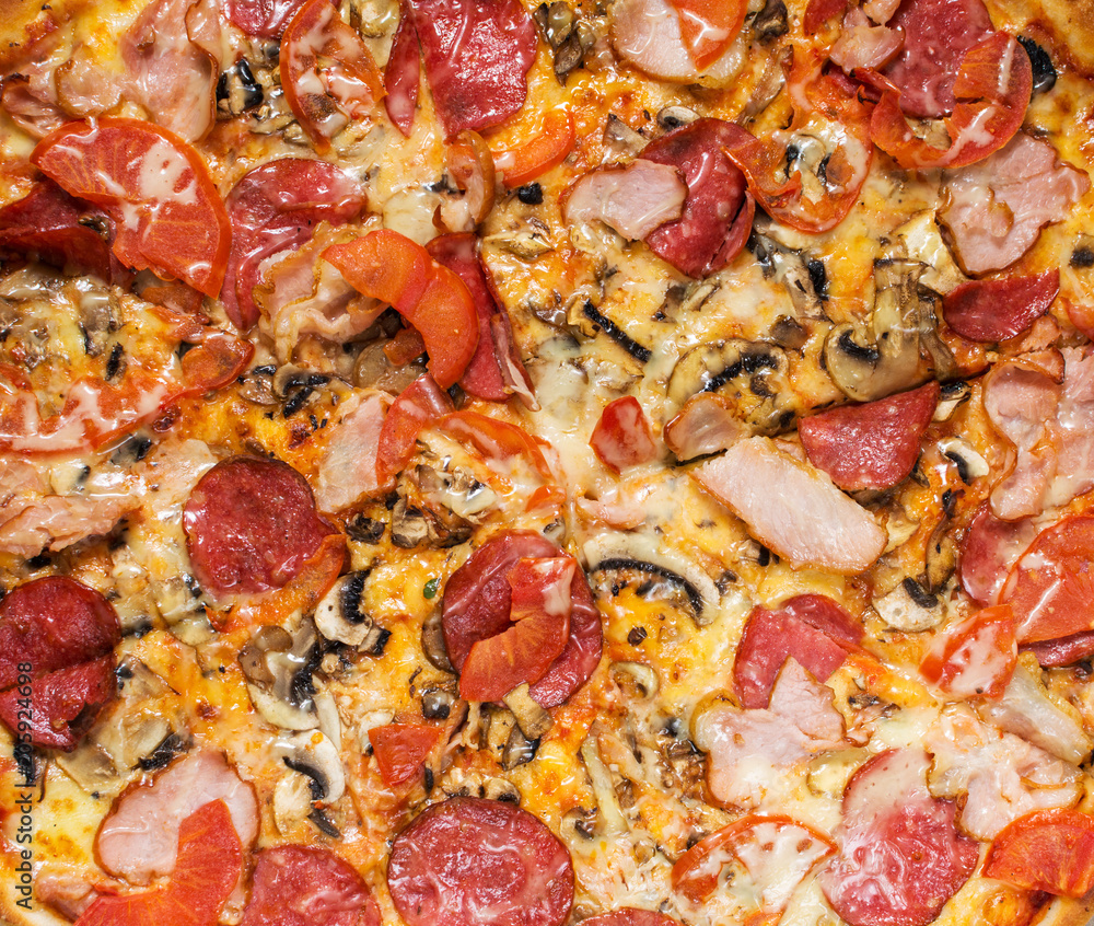 Fresh homemade pizza with pepperoni, ham, cheese and tomato sauce Fresh homemade pizza with pepperoni, ham, cheese and tomato sauce