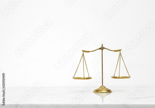 Golden scales balance put on white marble table counter with free space.