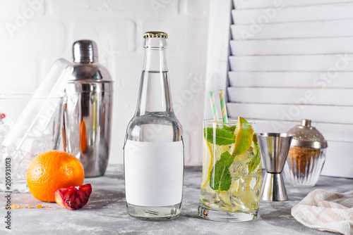 Mojito classic cocktail with lime and mint in a glass on white wooden background , photo