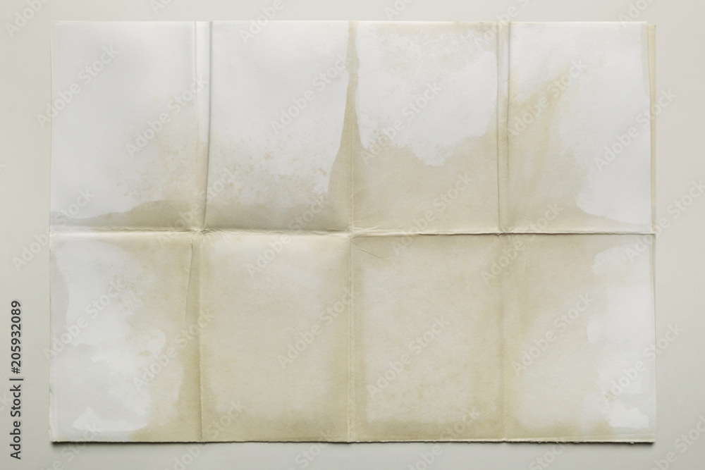 Empty sheet folded in eight, old paper isolated on gray background Empty sheet folded in eight, old paper isolated on gray background