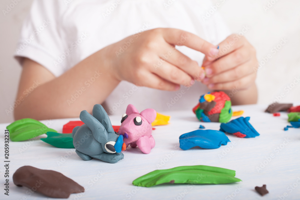 Development of small motor skills of children. Child sculpts from plasticine pig and bunny Development of small motor skills of children. Child sculpts from plasticine pig and bunny