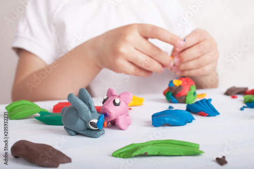 Development of small motor skills of children. Child sculpts from plasticine pig and bunny