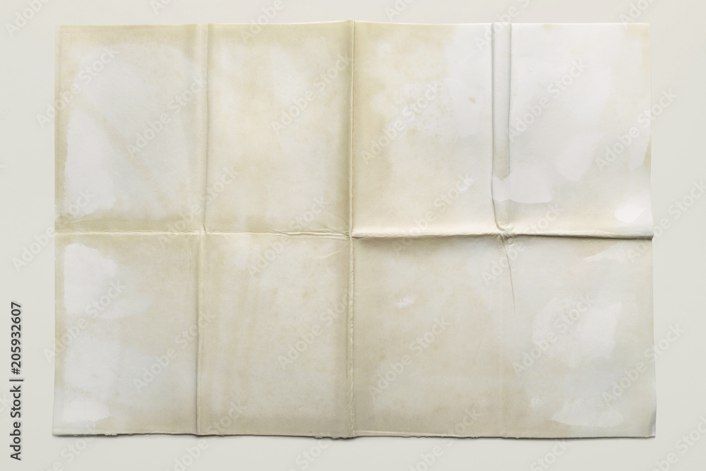 Empty sheet folded in eight, old paper isolated on gray background
