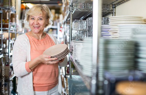 female buyer with clay plates in the tableware store photo