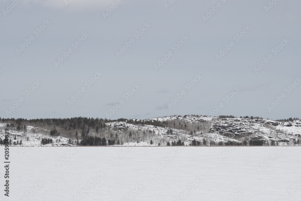hillside as seen across a frozen lake on a winter day
