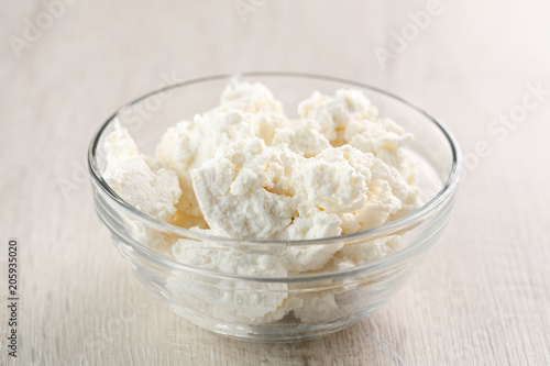 homemade Ricotta cheese in glass bowl on wooden table