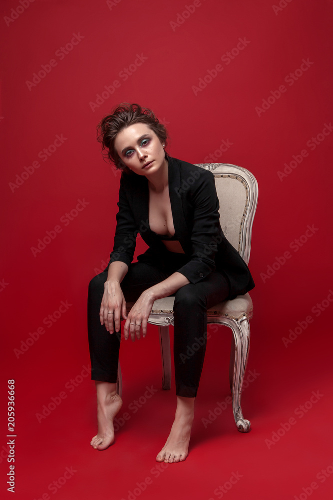 Smiling Woman With Bulletin Board Guts Pose Gesture Sitting In A Chair On  White Wall Background Stock Photo - Download Image Now - iStock