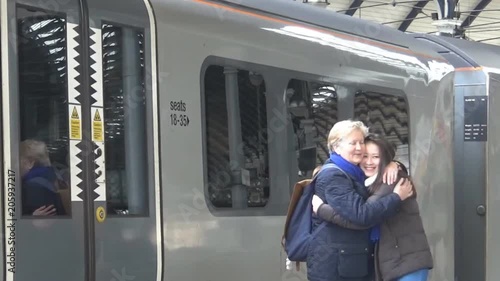 Grandmother gives her granddaughter a hug in front of a train, Newcastle upon Tyne, United Kingdom