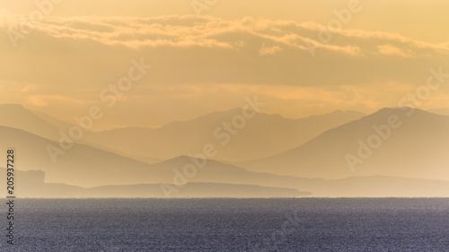 Silhouettes of hills over ocean