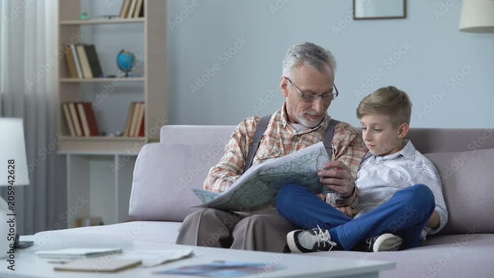 Grandfather veteran viewing map with grandson showing front line remembering war Grandfather veteran viewing map with grandson showing front line remembering war