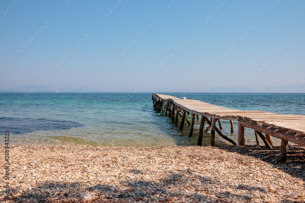 Fototapeta premium old jetty walkway pier and the sea. Stones beach. adventure Travel concept. wild beach. Copy space