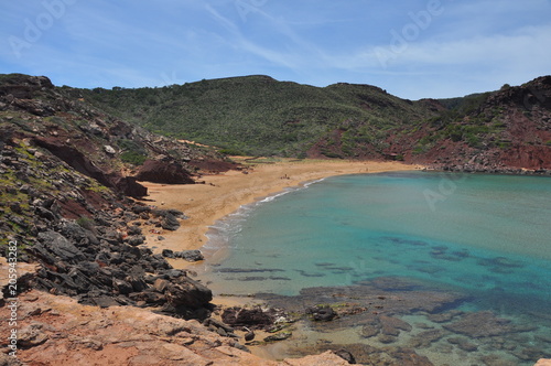 Küste und Strand mit roten Felsen, Menorca - Spanien