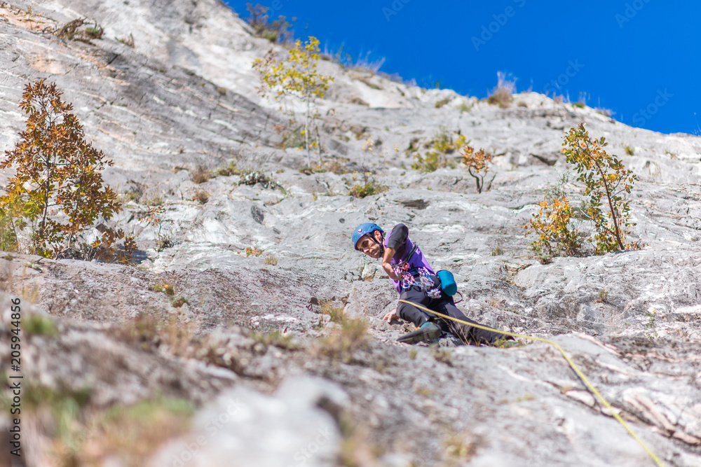 Young man lead climbing on cliff