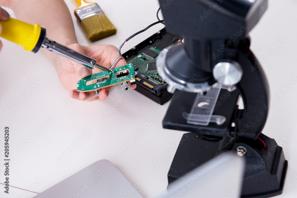 Engineer fixing broken computer hard drive Engineer fixing broken computer hard drive