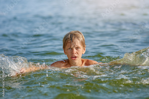 Happy little boy swimming in the river on summer weekend © Denys Kurbatov