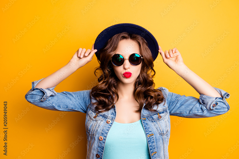 Portrait of cool charming girl holding hat on her head sending kiss with  pout lips isolated on yellow background having fashionable look, rest relax  leisure concept foto de Stock | Adobe Stock